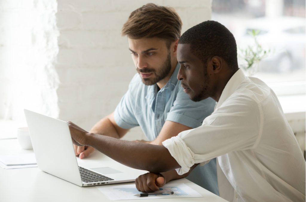 Coworkers analyzing online business on computer