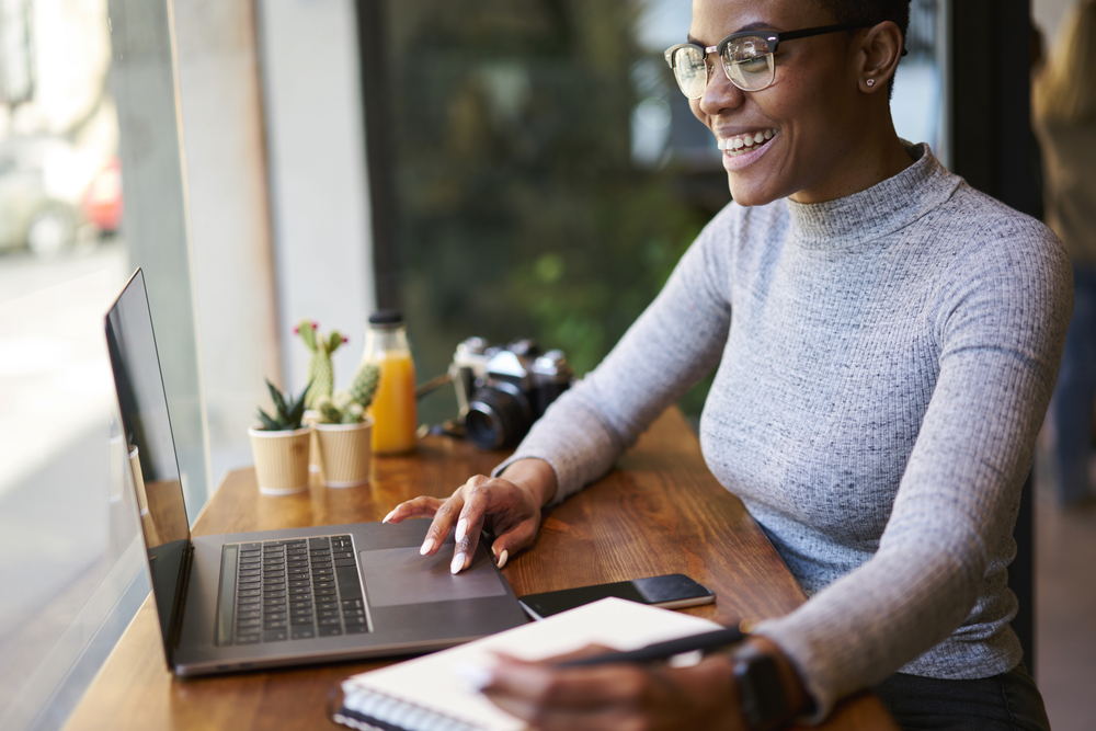 Businesswoman using computer and taking notes