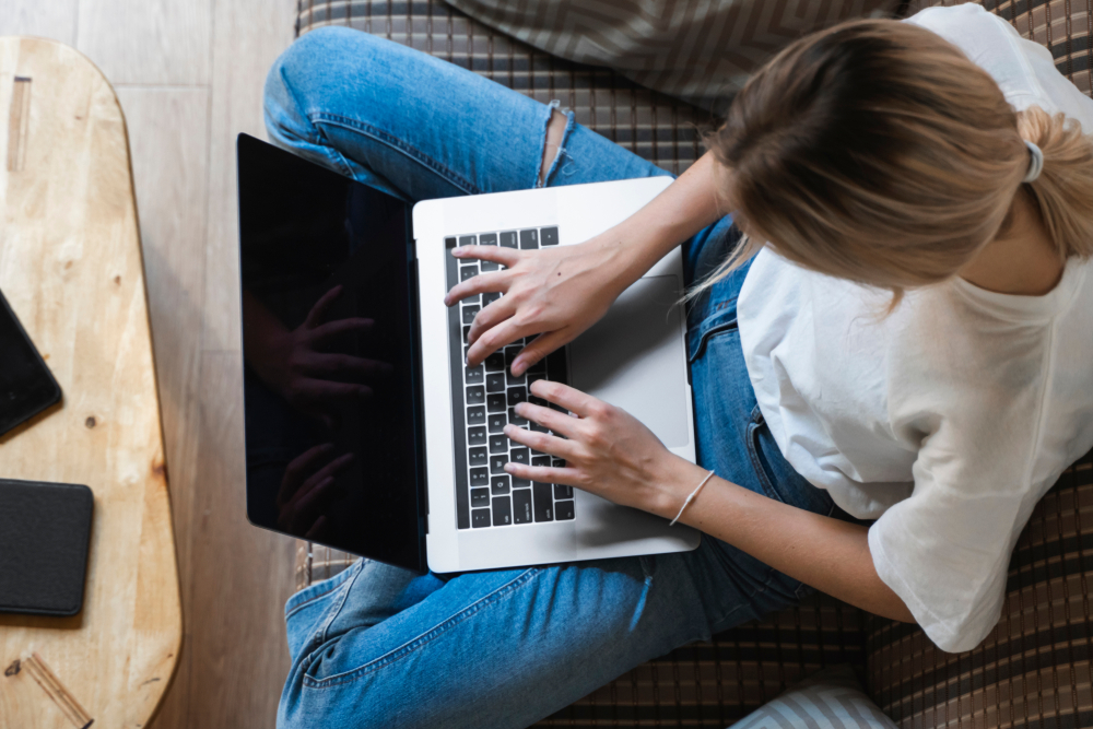 Overhead shot of woman working on laptop on couch