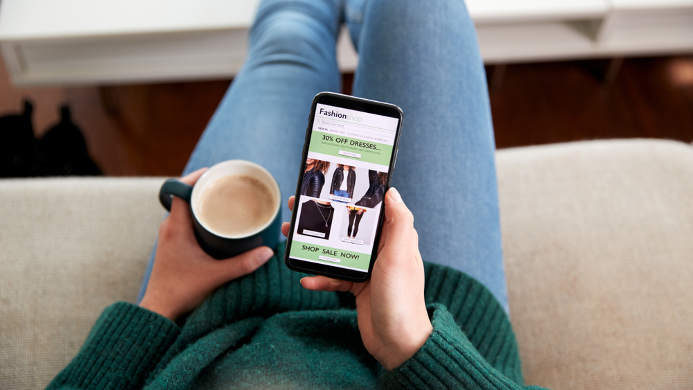 Close up of woman shopping for clothes online using mobile phone