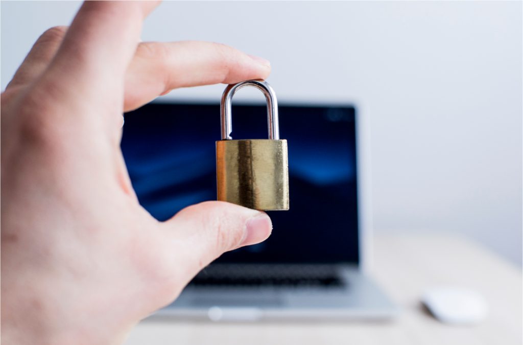 hand holding lock in front of computer